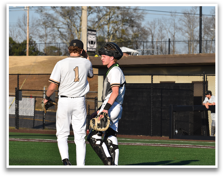 Two baseball players wearing white uniforms are talking to each other on the field. AI generated content
