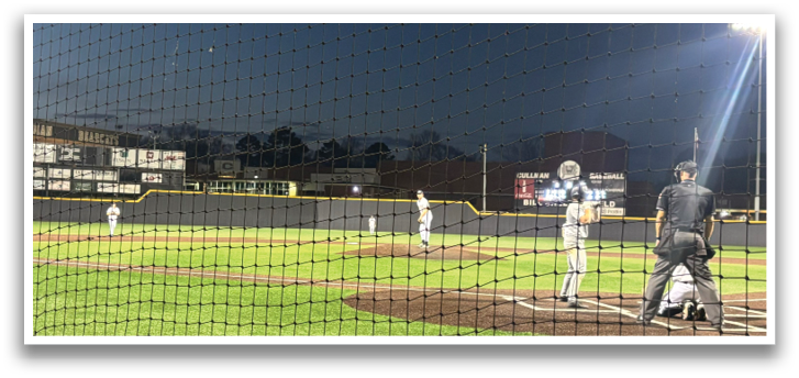 A baseball game is taking place at night with a crowd of people watching. The players are on the field, and the umpire is ready to make a call. AI generated content