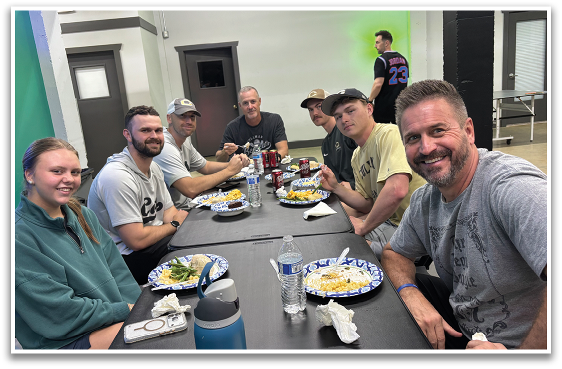 A group of people are sitting around a table, enjoying a meal together. AI generated content