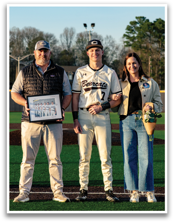 A man and woman pose with a baseball player on a field. AI generated content