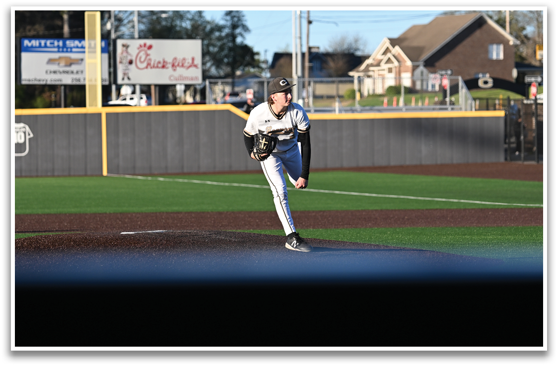 A baseball player is standing on the pitcher's mound, wearing a black and white uniform. He is holding a baseball in his hand and appears to be in the process of throwing it. AI generated content