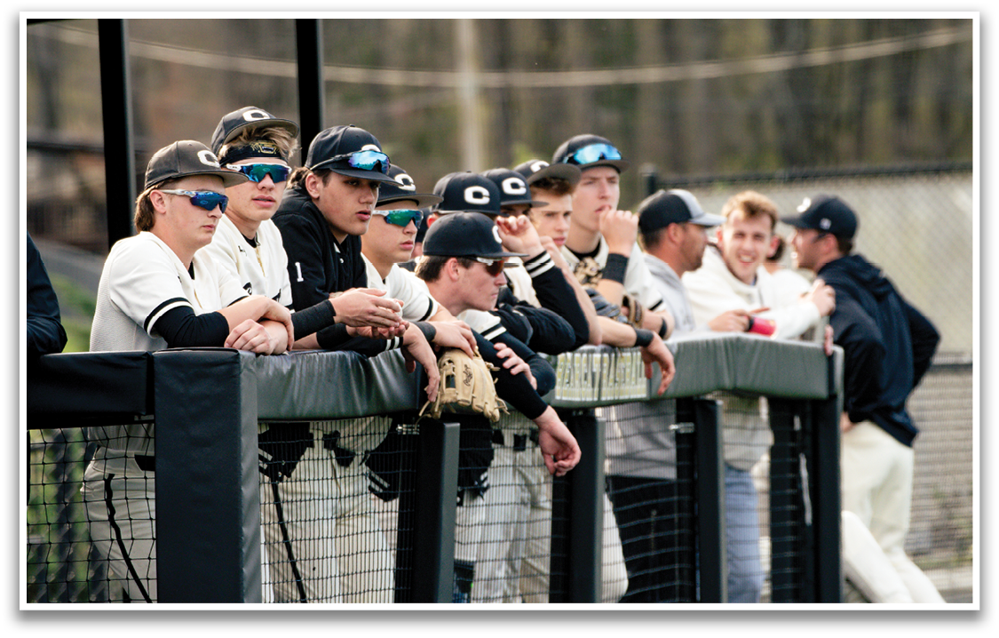 A group of baseball players are sitting on a bench, watching the game. AI generated content