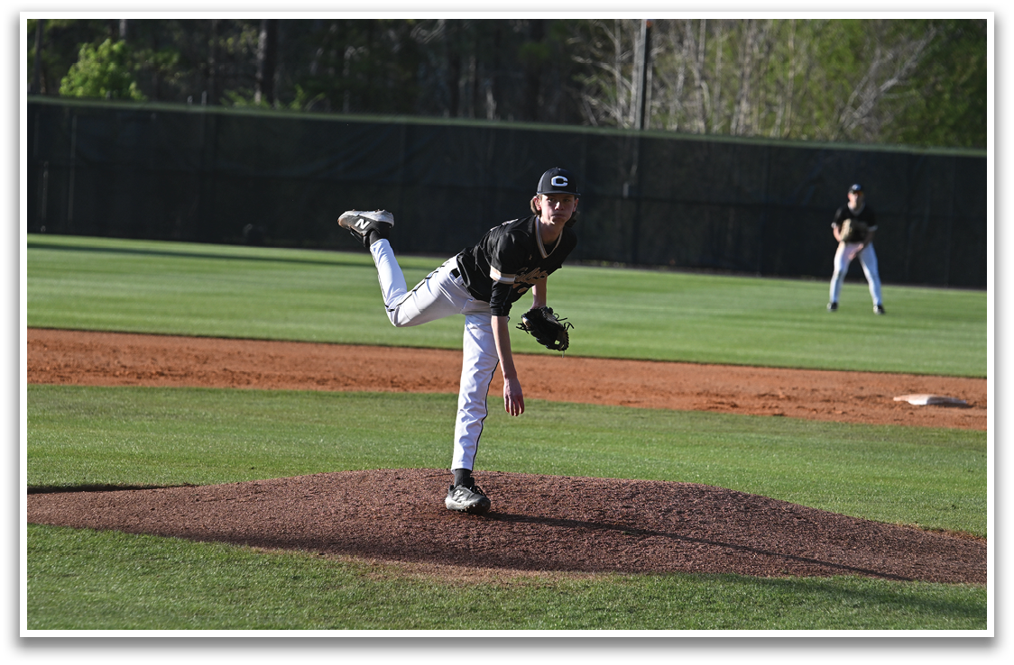A baseball player in a black shirt and white pants is pitching a ball on a field. AI generated content