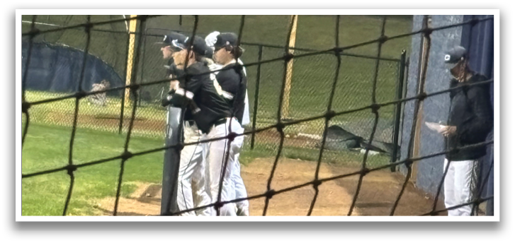 A group of men are standing on a baseball field, with one man holding a baseball bat. AI generated content