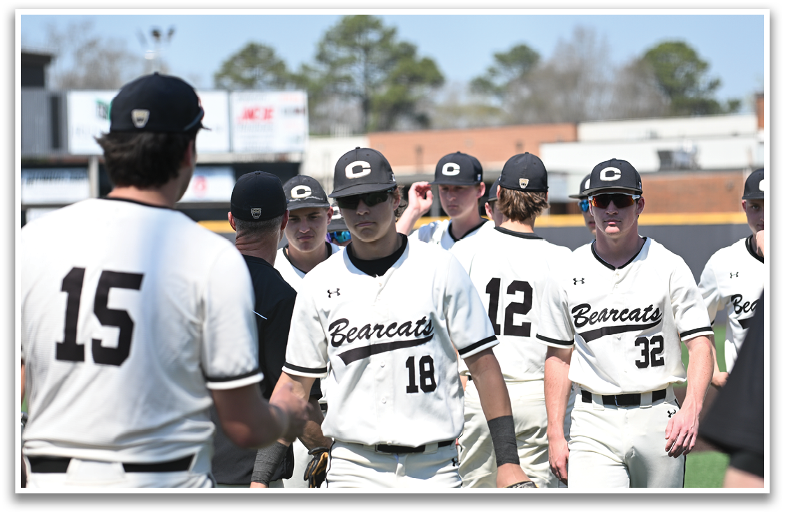 A group of baseball players wearing white uniforms and black caps are walking on a field. AI generated content