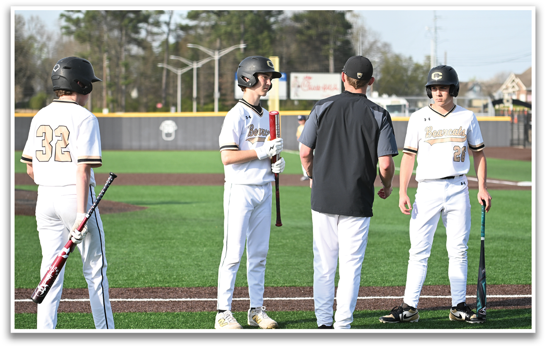 Four baseball players standing on a field, holding bats and wearing helmets. AI generated content