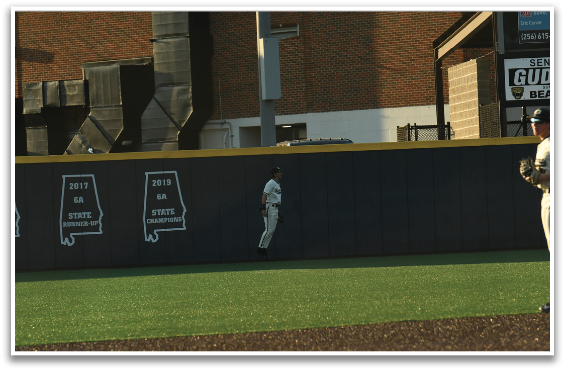 Two baseball players are standing on a field, one of them holding a baseball glove. AI generated content