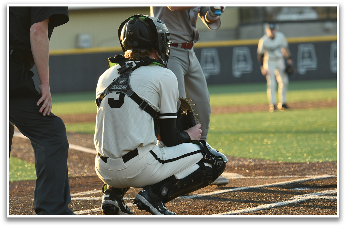 A baseball player is kneeling on the field, wearing a catcher's mitt and a helmet. AI generated content