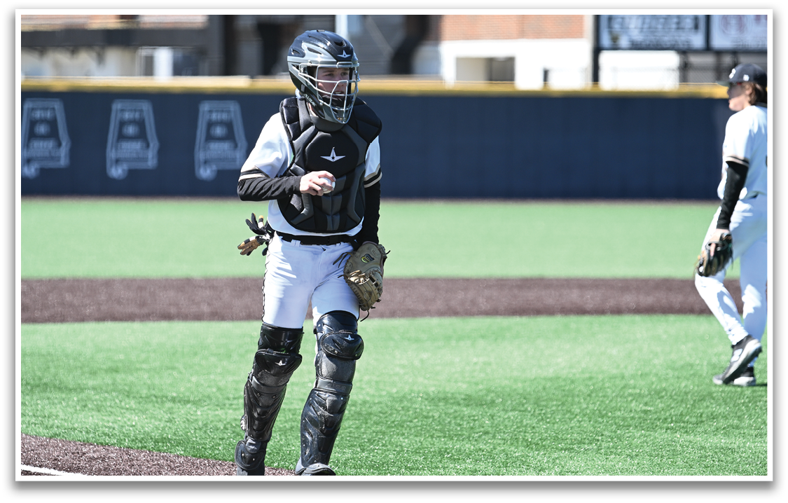 A baseball player wearing a catcher's mitt and chest protector walks across the field. AI generated content