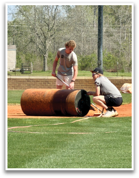 Two men are working on a large pipe on a field. AI generated content