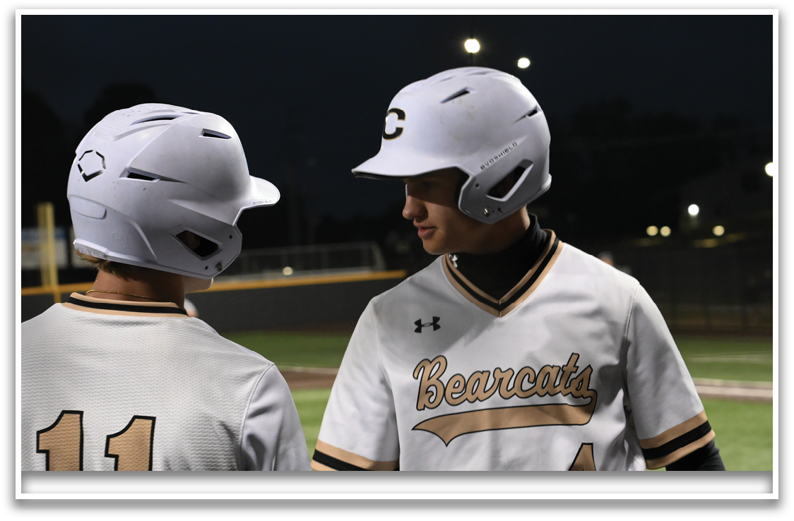 Two baseball players wearing helmets and uniforms. AI generated content