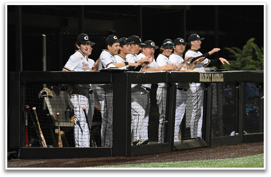 Baseball players in uniforms are sitting on a bench. AI generated content