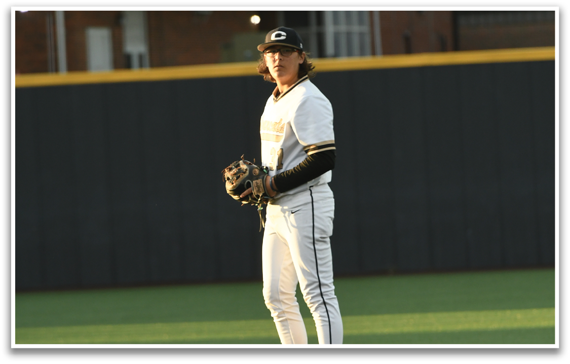 A baseball player in a white uniform stands on the pitcher's mound, holding a baseball glove. AI generated content