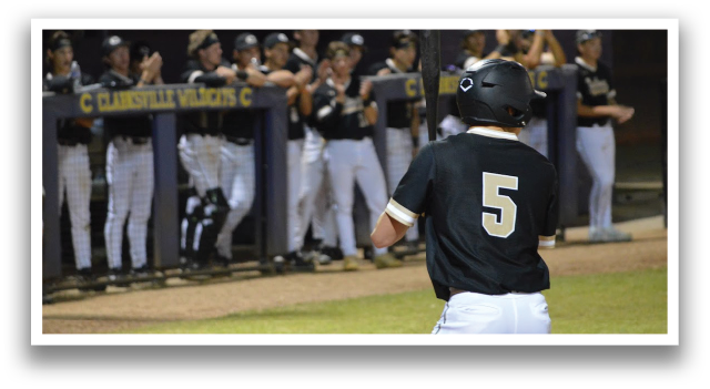 A baseball player in a black shirt and white pants is holding a bat, preparing to hit the ball. The player is surrounded by his teammates, who are watching and cheering him on. AI generated content