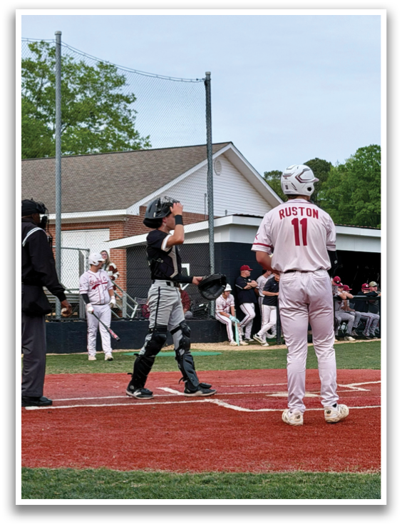 A baseball game is in progress with a batter, catcher, and umpire at the plate. The batter is holding a bat, ready to swing, while the catcher and umpire are in position behind him. The scene takes place on a baseball field with a crowd of spectators watching the game. AI generated content