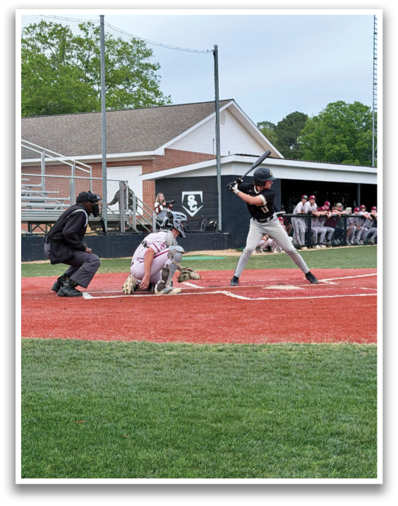 A baseball game is in progress with a batter swinging a bat at a ball. The catcher is positioned behind the batter, ready to catch the ball. There are several other players on the field, some of them holding baseball bats. The scene takes place in a baseball field with a bench in the background. AI generated content