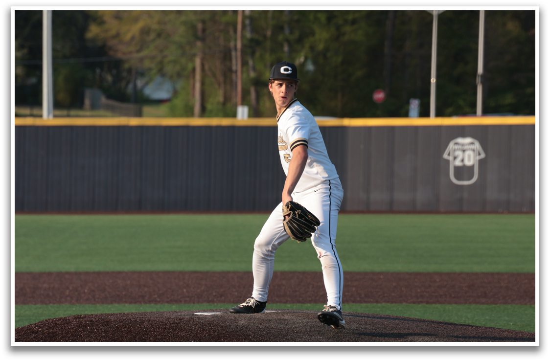 A baseball player in a white uniform stands on the pitcher's mound, preparing to throw the ball. AI generated content