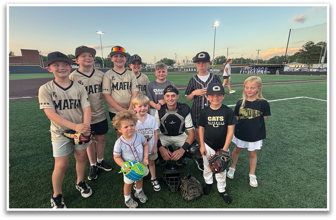 A group of children and a man pose for a photo on a baseball field. AI generated content