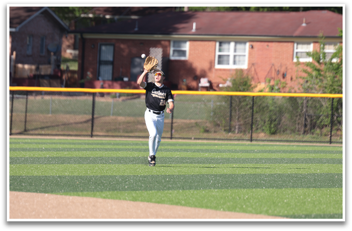 A baseball player in a black shirt and white pants catches a ball on a field. AI generated content