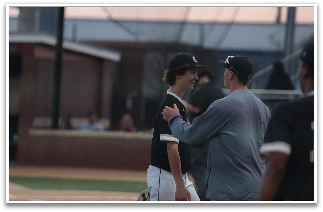 Two men in baseball uniforms shake hands on a field. AI generated content