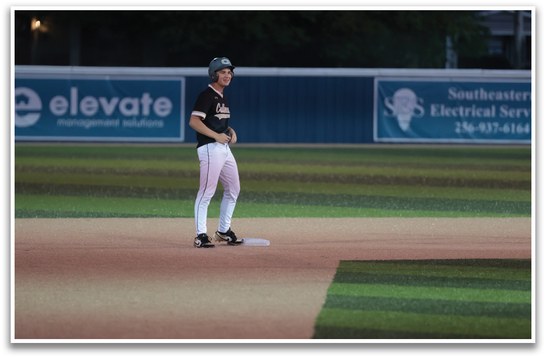 A baseball player is standing on a field with a bat, wearing a helmet and a black shirt. AI generated content