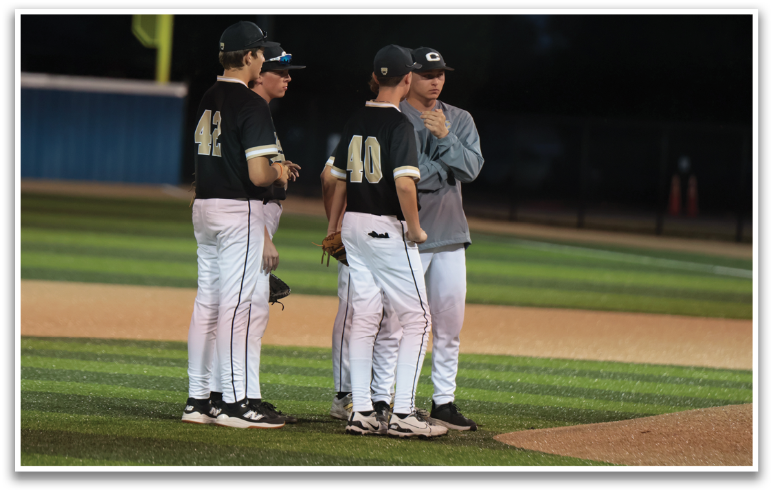 Three baseball players wearing black and white uniforms are standing on a field. One of the players is talking to the coach, while the other two are listening. They are all holding baseball gloves. AI generated content