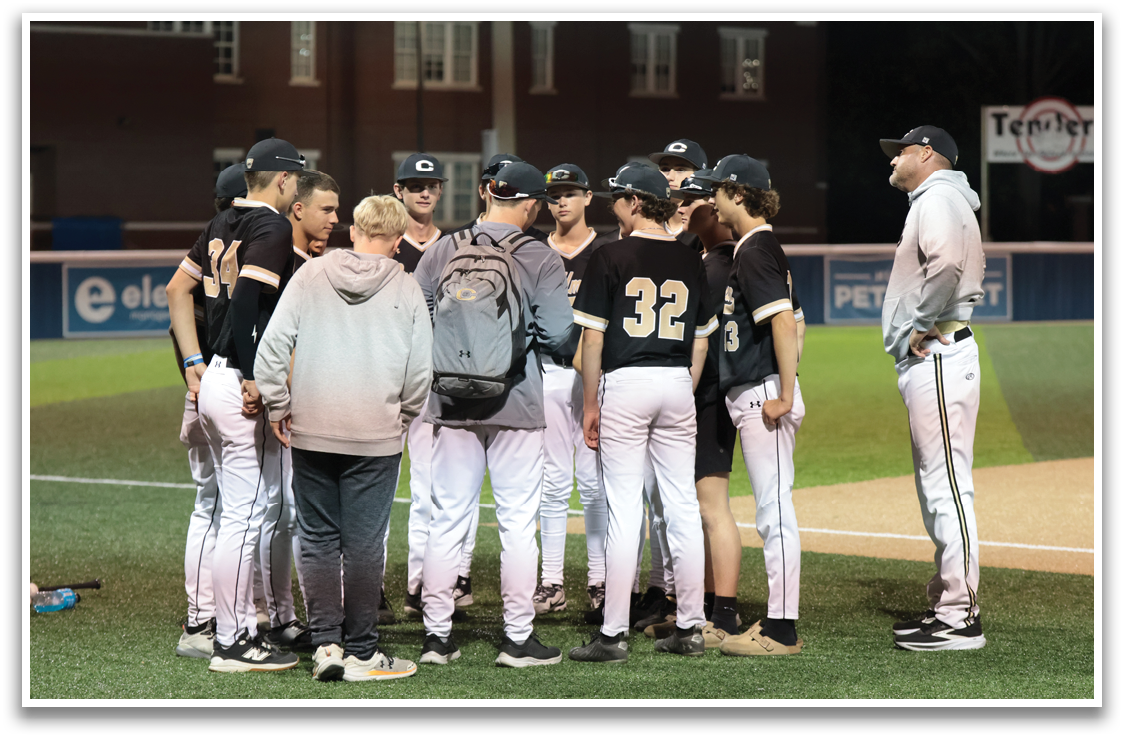 A group of baseball players wearing black and white uniforms are gathered on the field. AI generated content