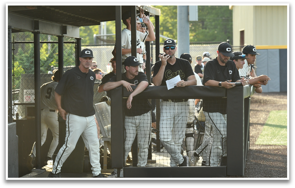 Baseball players are sitting on a bench, some of them talking on their cell phones. AI generated content