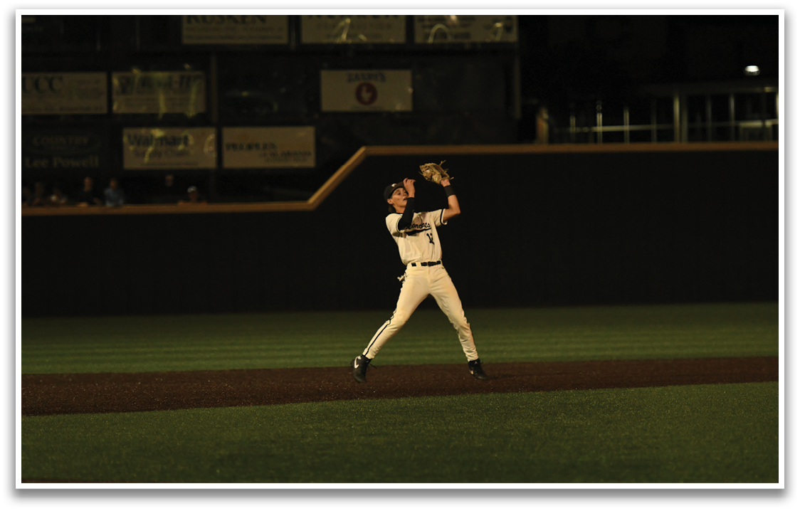 A baseball player catching a ball in a field. AI generated content