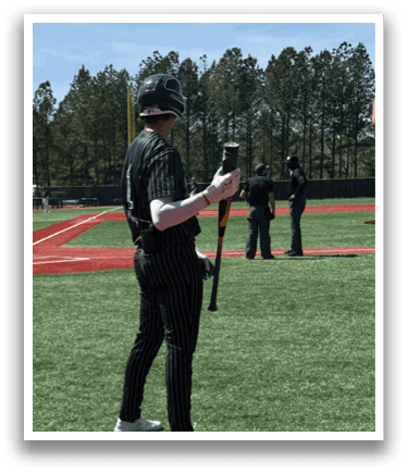 A baseball player is standing on the field holding a bat. Description generated by AI