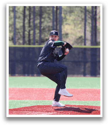 A baseball player in a black and white uniform is pitching a ball. Description generated by AI