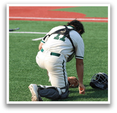 A baseball player kneeling on the ground with a catcher's mitt on his hand. Description generated by AI