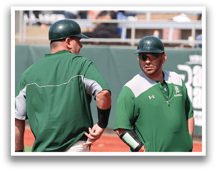 Two men wearing green shirts and sunglasses. Description generated by AI