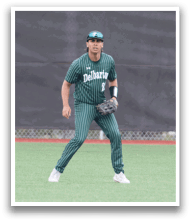 A baseball player in a green and white uniform is standing on a field. Description generated by AI
