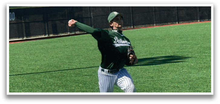 A baseball player wearing a green shirt and white pants is throwing a ball on a field. Description generated by AI