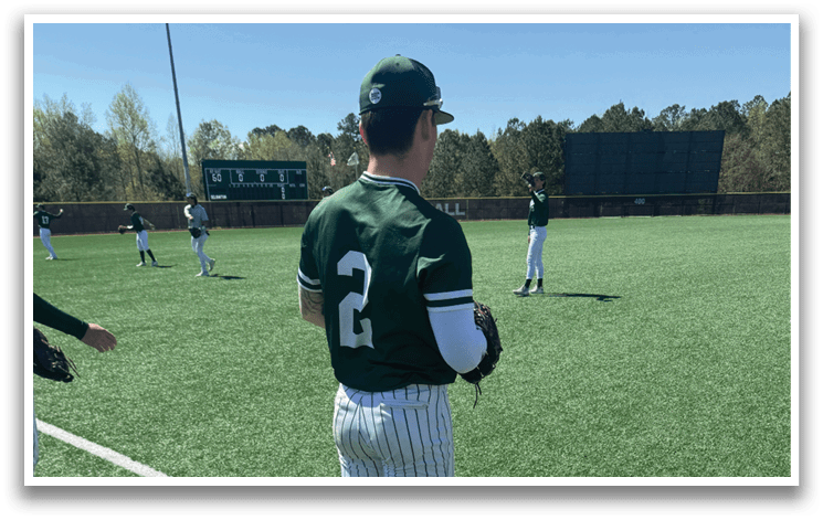 A baseball player wearing a green and white uniform. Description generated by AI