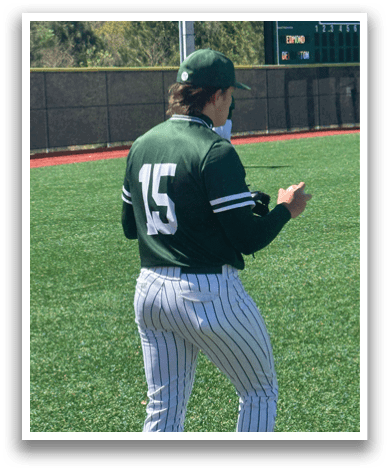 A baseball player wearing a green shirt and white pants. Description generated by AI