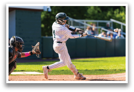 A baseball player is at bat, wearing a black and white uniform. Description generated by AI