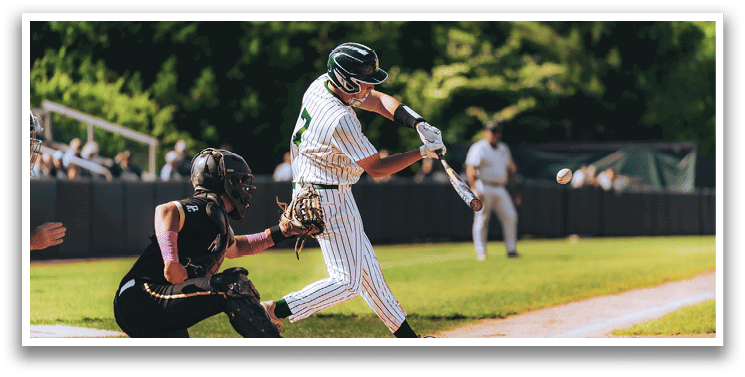 A baseball game is taking place with a man in a black shirt and gray pants standing behind a catcher. Description generated by AI