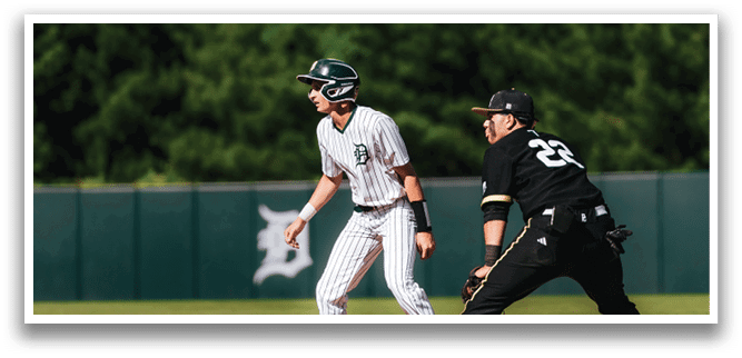 A baseball player is at bat, holding a bat and wearing a black and white uniform. Description generated by AI