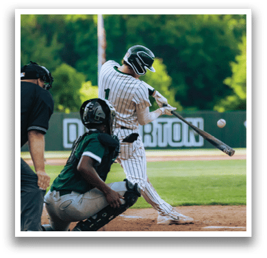 A baseball player in a striped uniform is swinging a bat. Description generated by AI