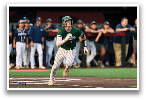 A baseball player in a black shirt and black socks is bending over to catch a ball. Description generated by AI