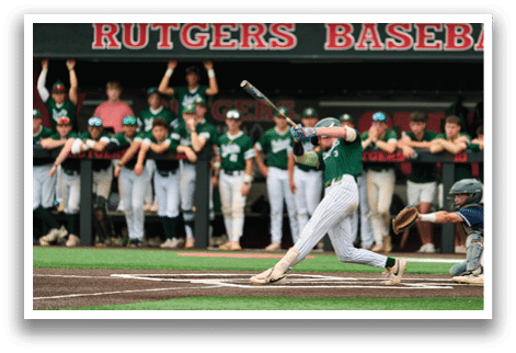 A baseball player in a black shirt and black socks is bending over to catch a ball. Description generated by AI