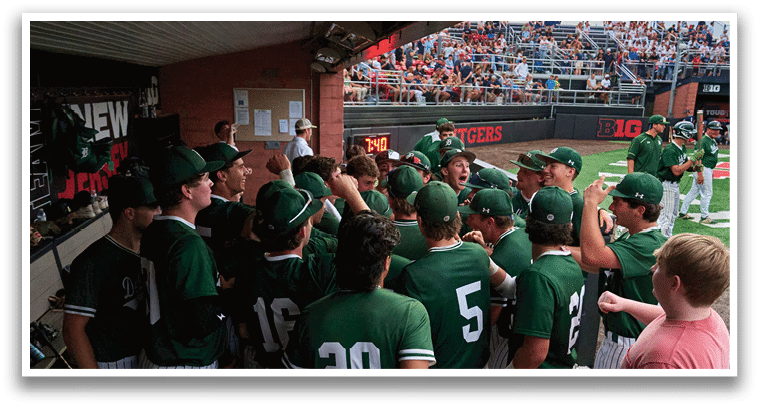 A group of young men in green and white uniforms pose for a picture. Description generated by AI