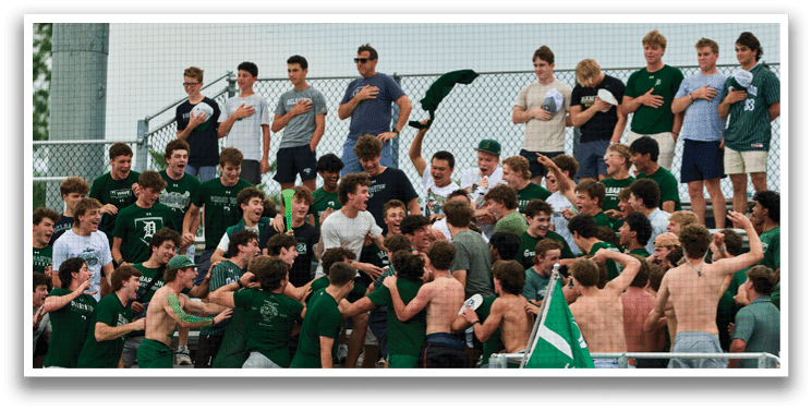 A group of young men wearing green and white uniforms. Description generated by AI