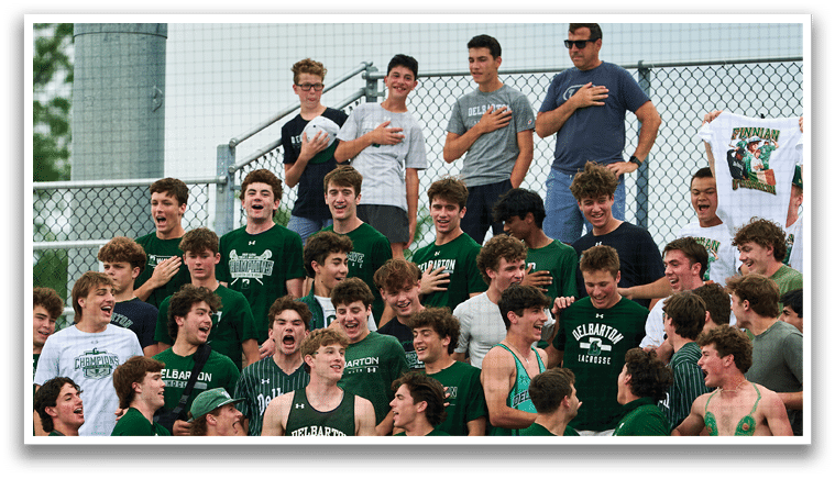 A group of young men in green and white uniforms pose for a picture. Description generated by AI