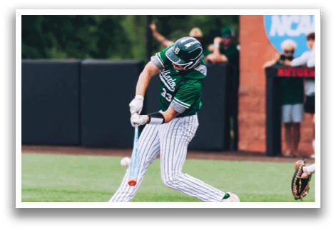 A baseball player in a black shirt and black socks is bending over to catch a ball. Description generated by AI
