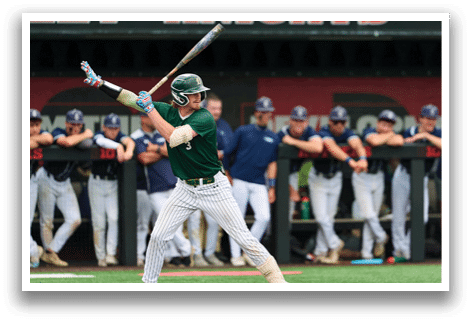 A baseball player in a black shirt and black socks is bending over to catch a ball. Description generated by AI