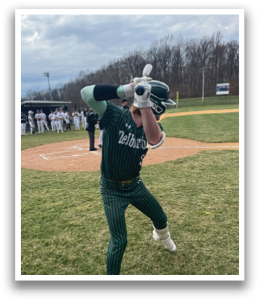 A baseball player in a green and white uniform is swinging a bat. Description generated by AI