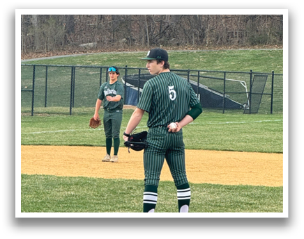 A baseball player wearing a green and white uniform stands on the pitcher's mound. Description generated by AI